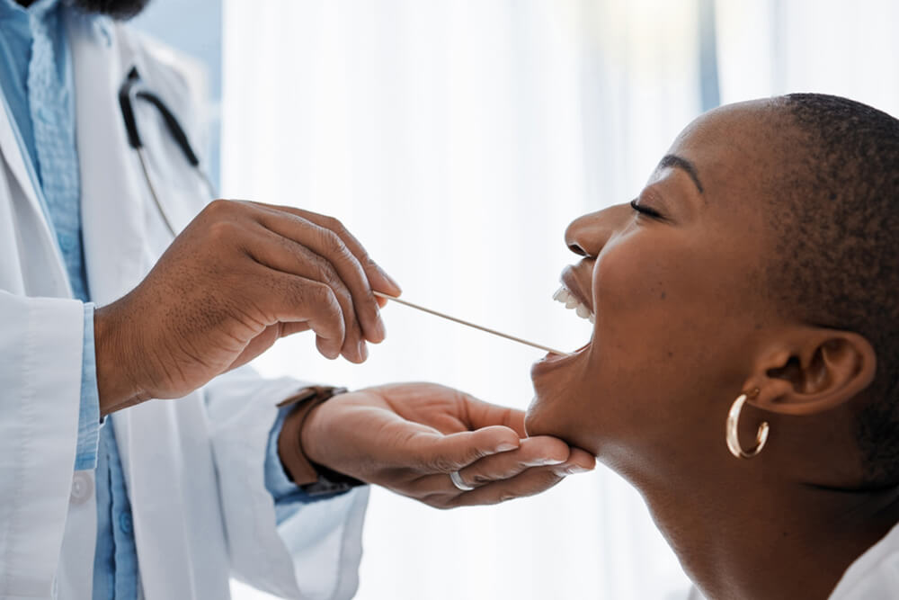 A woman undergoing a medical examination by a doctor in a clinical setting.